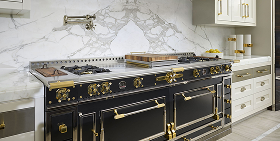 Black and brass La Cornue range in a marble kitchen